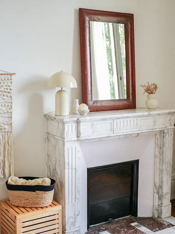 chambre avec une cheminée en marbre et un miroir posé dessus